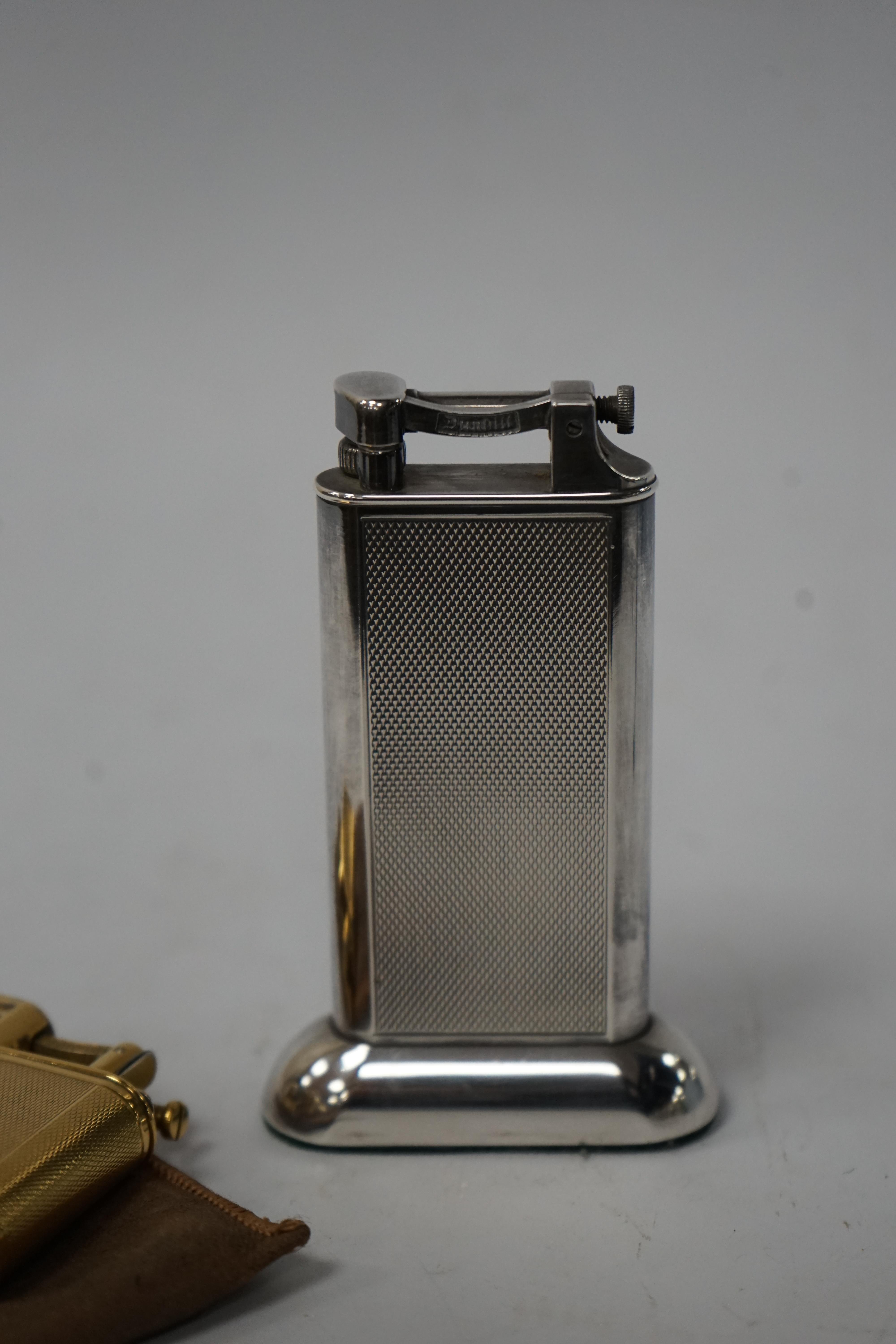 Two Dunhill lighters to include a plated table lighter, largest 10cm high. Condition - fair to good, not working